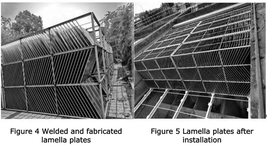 Workshop assembly of 304 stainless steel inclined plates showing welding of plates to angle steel frame at 60-degree inclination